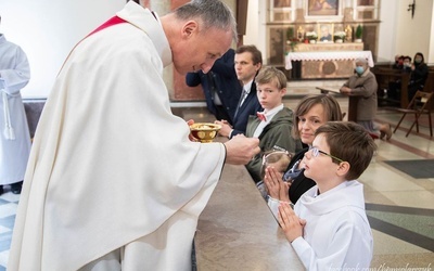 Bp. Marek Solarczyk udziela Komunii św. Michałowi