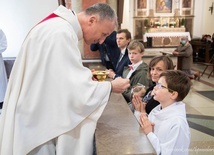 Bp. Marek Solarczyk udziela Komunii św. Michałowi