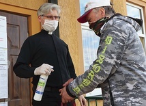 Dezynfekcja dłoni przed budynkiem organizacji w Olsztynie.