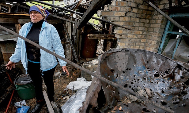 Tatiana Sergienko obok swojego zniszczonego 3 maja 2020 r. domu w mieście Gorłowka koło Doniecka (Ukraina).