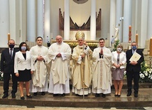 Neoprezbiterzy z arcybiskupem i rodzicami.