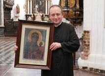 Ks. Krystian Kletkiewicz, proboszcz parafii archikatedralnej, prezentuje obraz peregrynujący niegdyś po rodzinach.