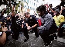 Dowódca policji Los Angeles Cory Palka klęczy razem z czarnoskórymi uczestnikami protestu po śmierci George’a Floyda. Ta demonstracja miała charakter pokojowy, ale nie zawsze tak było.