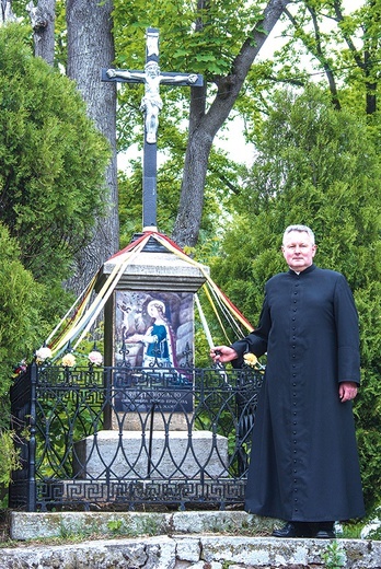 ▲	Ks. Wojciech Marchewka przy krzyżu, gdzie umieszczono wizerunek świętej.