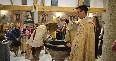 ▲	Ks. Andrzej Lojtek i Weronika Ożarowska w czasie nabożeństwa z odnowieniem przyrzeczeń chrzcielnych na oazie w Sychowie.