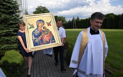 Katarzyna i Tomasz Śmiertkowie niosą ikonę Matki Bożej. Z prawej ks. proboszcz Andrzej Mirek.