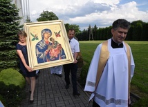 Katarzyna i Tomasz Śmiertkowie niosą ikonę Matki Bożej. Z prawej ks. proboszcz Andrzej Mirek.