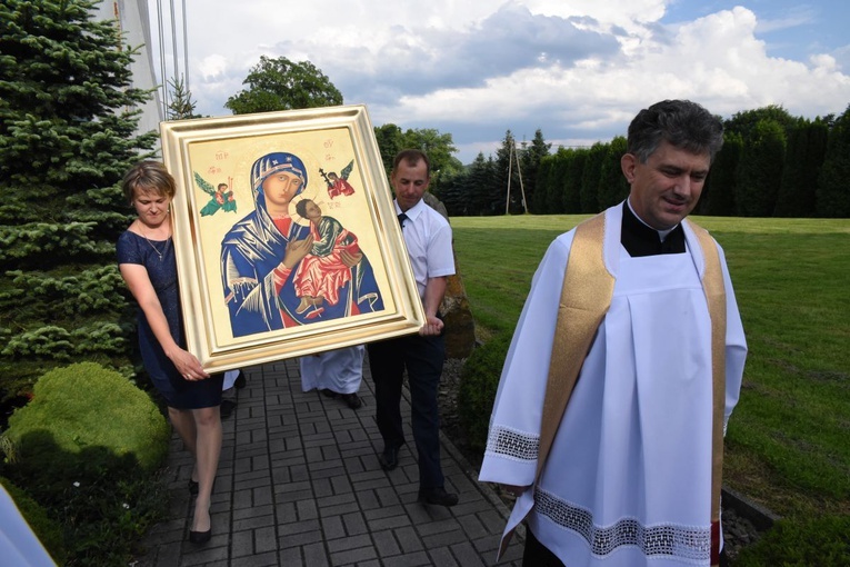 Katarzyna i Tomasz Śmiertkowie niosą ikonę Matki Bożej. Z prawej ks. proboszcz Andrzej Mirek.