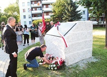 ▲	Przed pamiątkową tablicą złożono kwiaty i zapalono znicze.