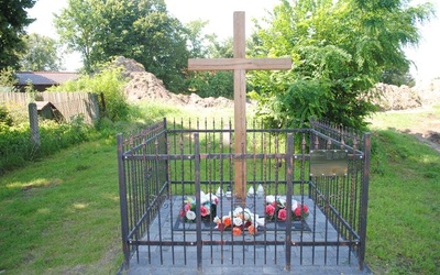 Żabno. Krzyż i tablica upamiętniająca pomordowanych.