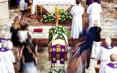 Żałobnicy przechodzą obok trumny podczas Mszy.