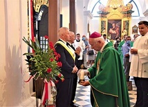 Pod tablicą złożono kwiaty.