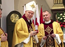 ▲	Ks. Kryspin Rak wręczył bp. Turzyńskiemu medal „W służbie Bogu i Ojczyźnie” i okolicznościowy ryngraf.