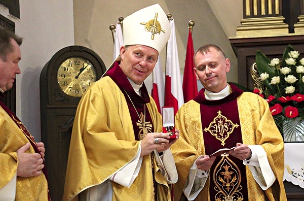 ▲	Ks. Kryspin Rak wręczył bp. Turzyńskiemu medal „W służbie Bogu i Ojczyźnie” i okolicznościowy ryngraf.