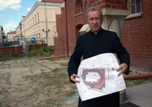 Ks. Mirosław Nowak pokazuje plany drogi procesyjnej wokół kościoła pw. św. Jana Chrzciciela.