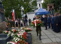 Kwiaty przy pomniku katyńskim składają przedstawiciele służb mundurowych.