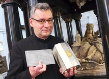 Ks. Piotr Filas SDS trzyma relikwie świętej niespodziewanie odnalezione w sarkofagu w marcu tego roku.