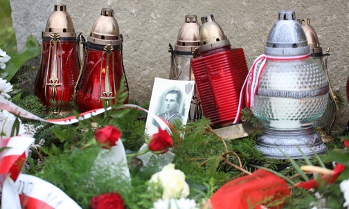 Białe i czerwone znicze zapłonęły przy fotografii por. Kopika.