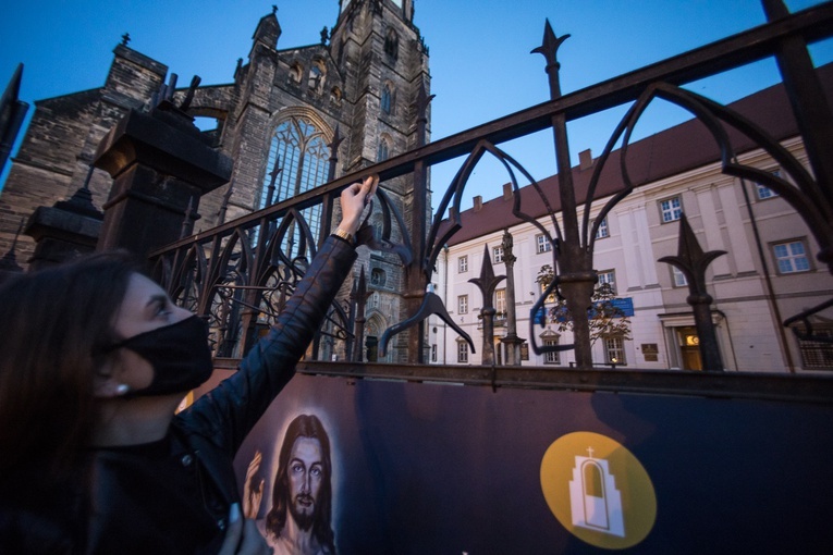 Kobieta w trakcie protestu wieszająca jeden z napisów.