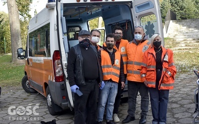 Ks. Radosław Kisiel z włoskimi wolontariuszami, którzy przywieźli ambulans.