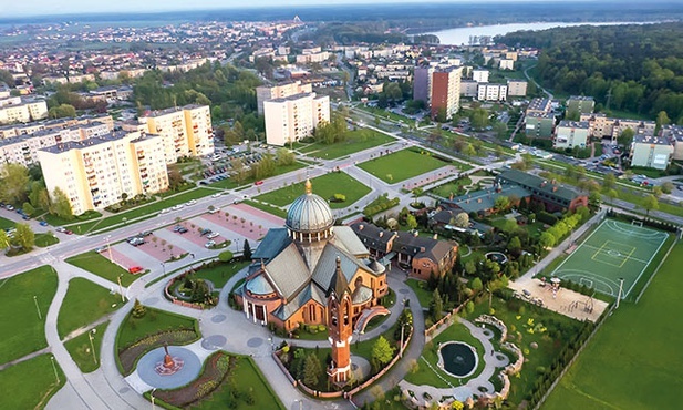 ▲	Świątynia jest bardzo malowniczo położona. W tle Jezioro Paprocańskie.