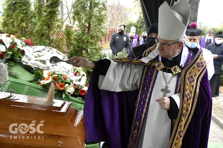 Bp Marek Mendyk posypujący ziemią grób śp. Władysława. 