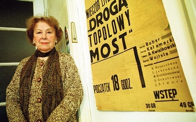 ▲	Kraków, 2005 rok. Artystka w swoim mieszkaniu, przy plakacie wieczoru literackiego studentów polonistyki z 1938 r., gdzie recytowała wiersze wraz z Karolem Wojtyłą.