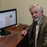 Piotr Kacprzak pokazuje na monitorze jedną ze stron publikacji, która jest dostępna w Internecie.