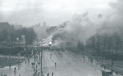 Walki uliczne w rejonie Huciska w Gdańsku 15 grudnia 1970 roku. W tle kościoły św. Mikołaja, św. Jana i Mariacki.