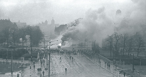 Walki uliczne w rejonie Huciska w Gdańsku 15 grudnia 1970 roku. W tle kościoły św. Mikołaja, św. Jana i Mariacki.