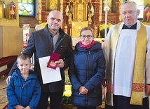 	Michał Gocal z żoną, synem i ks. Markiem Kitą.