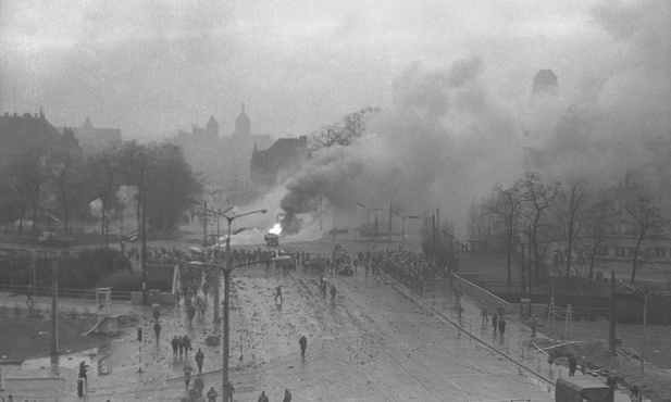 Walki uliczne w rejonie Huciska w Gdańsku 15 grudnia 1970 roku. W tle kościoły św. Mikołaja, św. Jana i Mariacki.