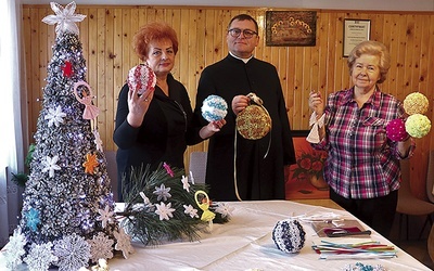 	Panie Genowefa (z prawej) i Marianna z ks. Gabrielem Marciniakiem prezentują świąteczne ozdoby.