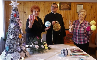 Panie Genowefa Mądra (z prawej) i Marianna Sieczkowska z ks. Gabrielem Marciniakiem prezentują świąteczne ozdoby.