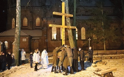 ▲	Krzyż ustawiono w miejscu, gdzie dawniej było wejście do świątyni. Świadczy o tym wydeptany kamień, jedyna pozostałość po starym kościele.