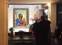W bocznej nawie wierni modlą się przy dużej ikonie Matki Bożej Częstochowskiej. 