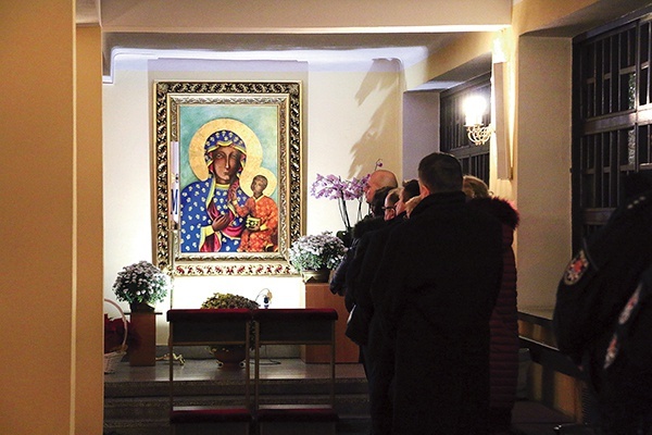 W bocznej nawie wierni modlą się przy dużej ikonie Matki Bożej Częstochowskiej. 