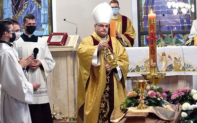 Ordynariusz świdnicki okadza trumnę zmarłego kapłana.