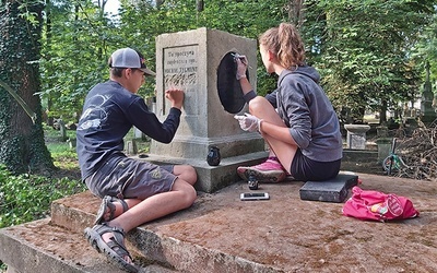 	Młodzi wolontariusze odnawiają napisy  na pomniku  grobowca Stadniczenków  na nekropolii  w Kołomyi.