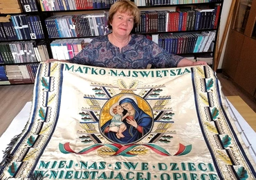 Anna Kulbacka prezentuje odnowiony sztandar z wizerunkiem Żyrowickiej Madonny.
