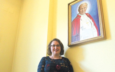 Dyrektor Dominika Warmuz przy portrecie patrona miejsca.