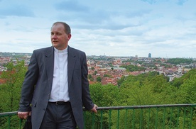 ▲	Ksiądz Wojciech Górlicki  na Górze Trzech Krzyży. W tle panorama miasta.