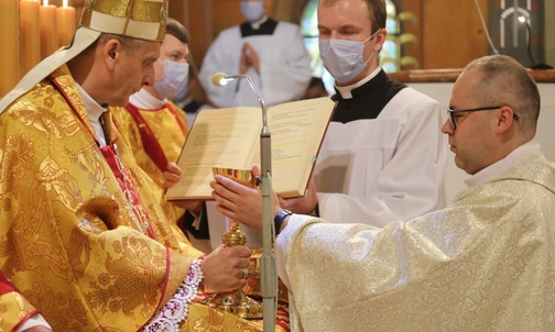 Bp Roman Pindel wręcza kielich i patenę ks. Pawłowi Stawarczykowi.