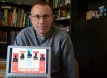 Ks. Mariusz Wilk z plakatem promującym projekt.