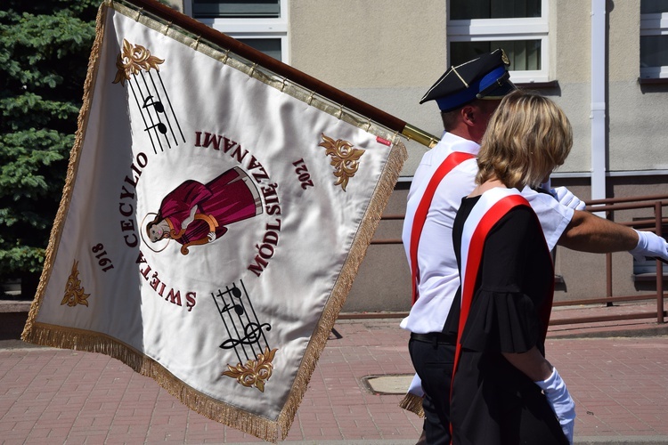 Na sztandarze widnieje także wizerunek św. Cecylii.