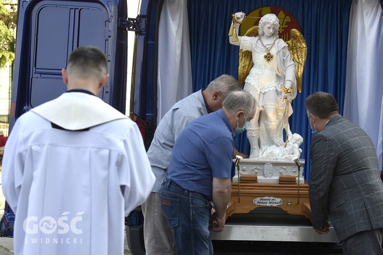 Przedstawiciele parafian wyjmujący figurę św. Michała Archanioła z ruchomej kaplicy.