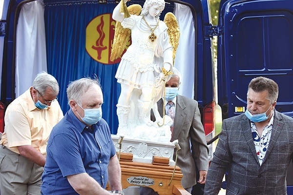 Mężczyźni przenieśli procesyjnie rzeźbę Michała Archanioła z ruchomej kaplicy do świątyni.