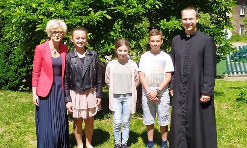 Luiza Jankowska, Tosia Kraszewska i Maksym Osak z dyrektor Aliną Prajzler i ks. Wojciechem Kamińskim.