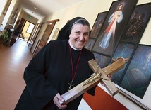 ◄	Siostra Michaela z krzyżem wykonanym z desek pochodzących z domu rodzinnego księdza Michała Sopoćki.