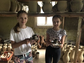 Amelia i Julia prezentują wykonane przez siebie gliniane kubki.